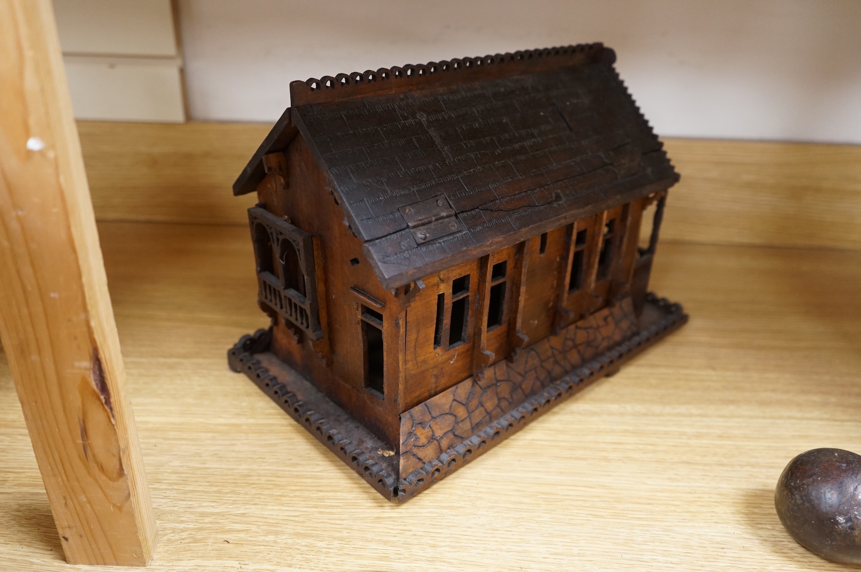 An early 20th century Black Forest carved walnut musical footed dish together with a model of a house (2)